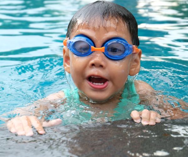 Image of a young boy playing in a pool.
